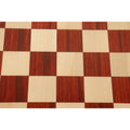 Symmetric top-down view of the alternating bud rosewood and maple wood squares on a chess board.