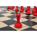 Single crimson camel bone pawn piece from the 1849 Jacques Cook set on a black and maple board.