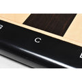 Macro view of a crisp white algebraic letter 'C' engraved on the polished ebony chess board border.