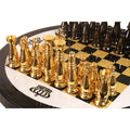 Polished gold brass chess pieces standing on a high-gloss black and gold chessboard.