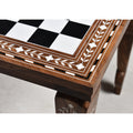 Close-up of the intricate floral leaf inlay on a golden rosewood and acrylic ivory chess board.
