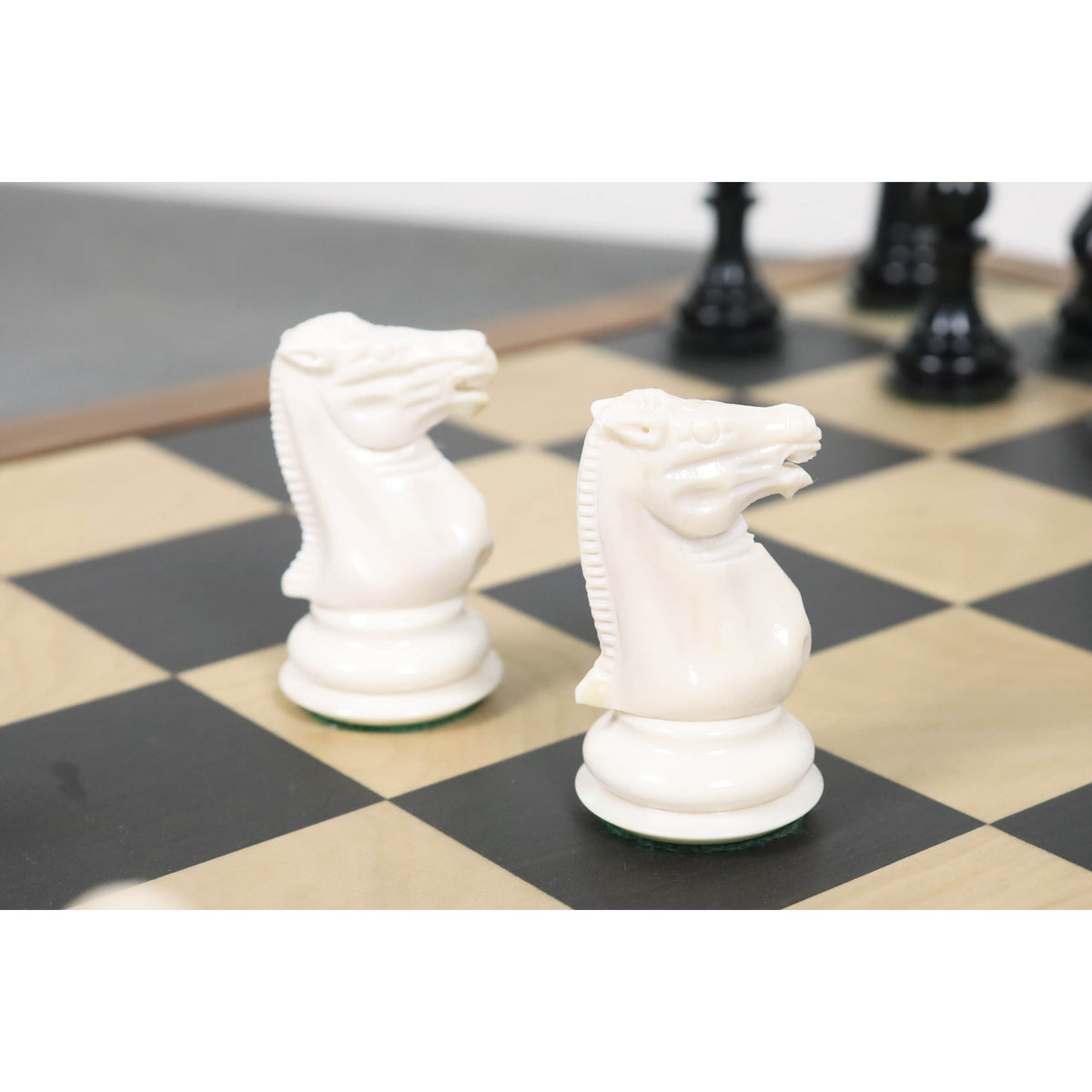 Close-up of two white camel bone knights showing intricate hand-carved details and vintage aesthetics.