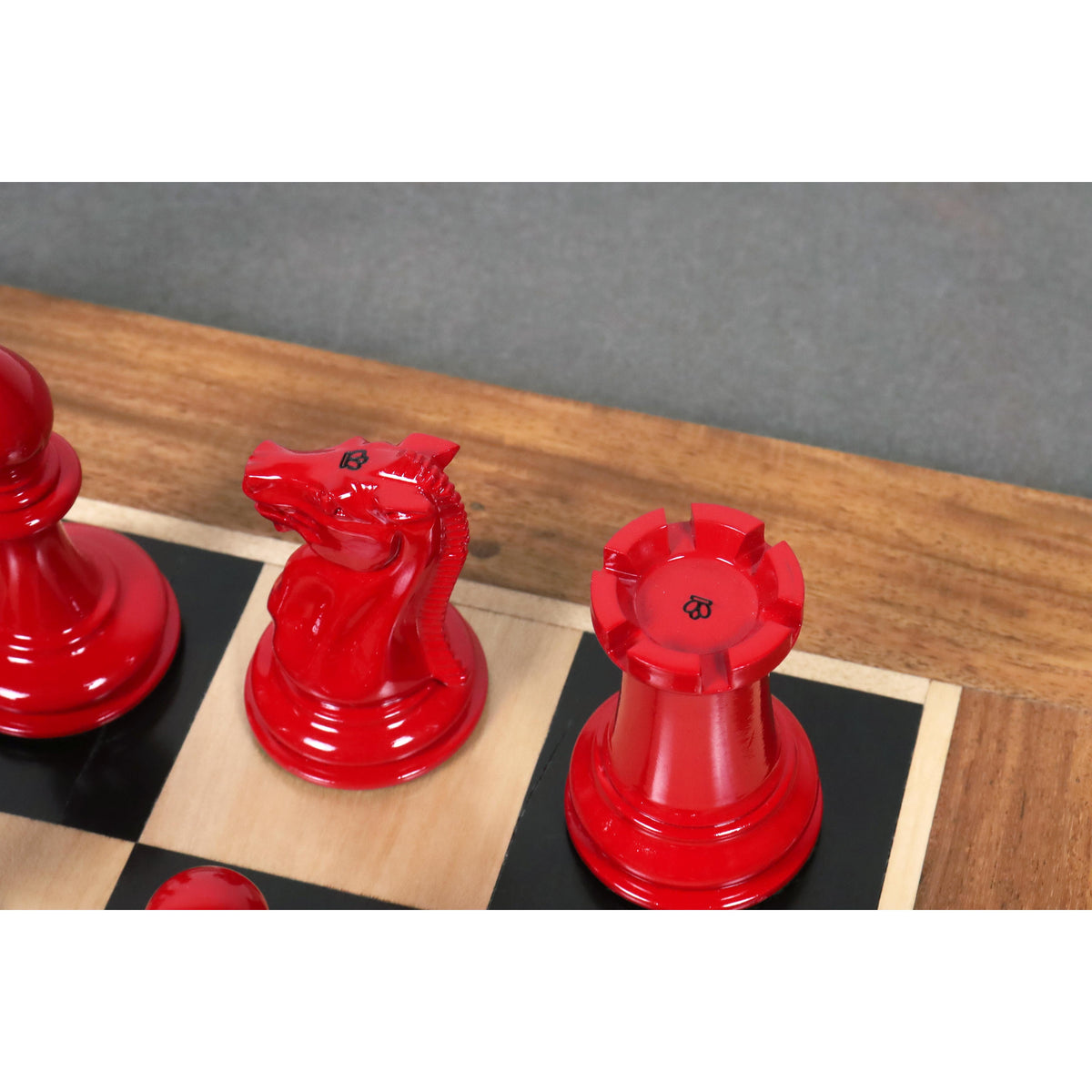 Crimson lacquer knight and rook with king-side stamps from the 1849-50 Leuchars Cook Staunton set.