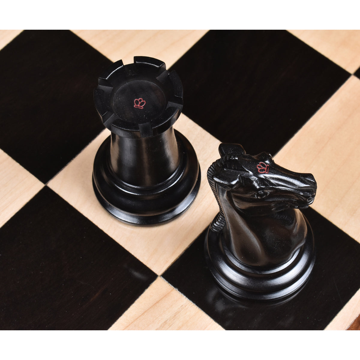 Ebony Rook and Knight showing the distinctive red crown stamps on the flat head surfaces.