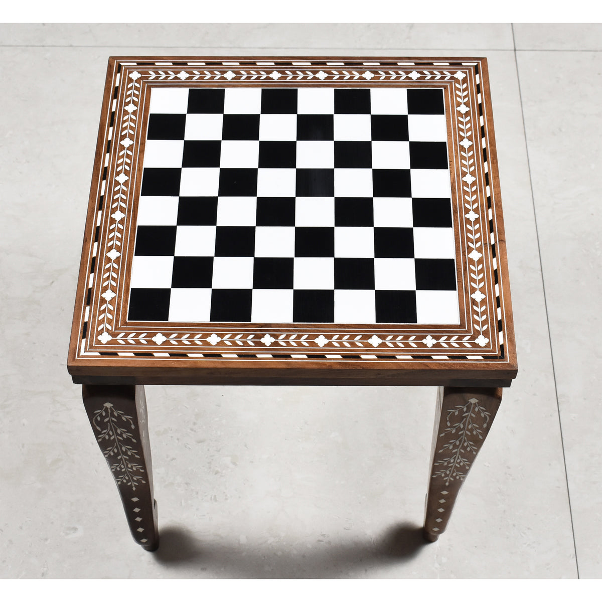 Overhead view of a 14 inch golden rosewood chess board with ivory acrylic floral border inlay.