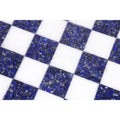 Macro shot of the blue stone and white marble checkered pattern on a luxury chess board.