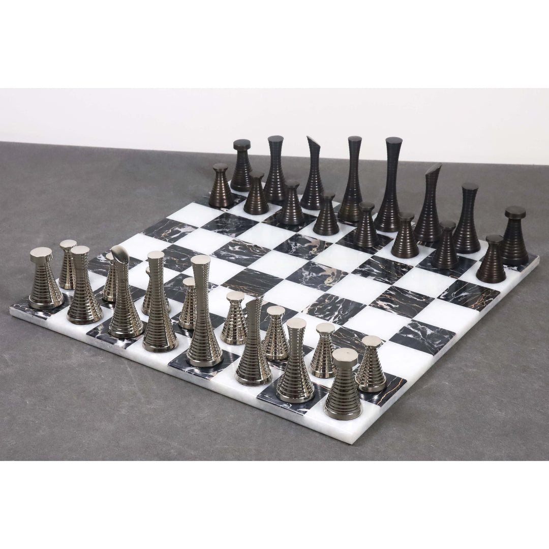 Modern metal chess pieces displayed on a 15 inch black and white marble stone board.
