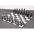 Modern metal chess pieces displayed on a 15 inch black and white marble stone board.