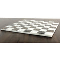Low profile shot of a luxury black and white marble stone chess board highlighting its sleek borderless edges.
