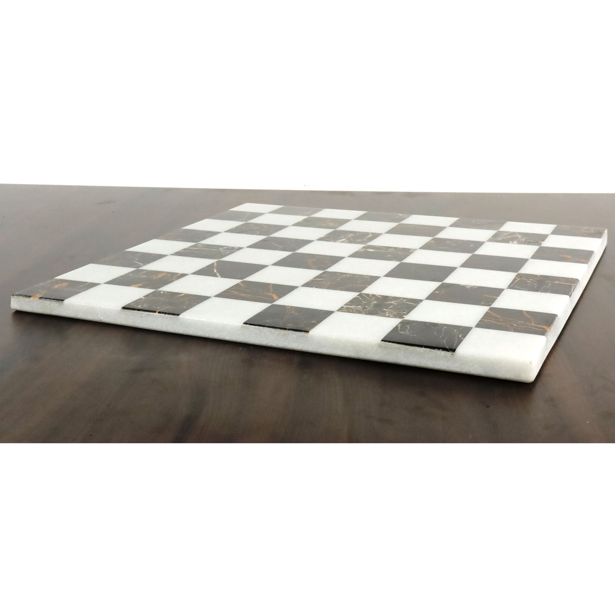 Low profile shot of a luxury black and white marble stone chess board highlighting its sleek borderless edges.