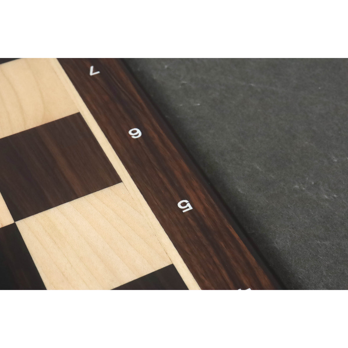 Detailed macro shot of the dark rosewood grain and white rank numbers on the board border.