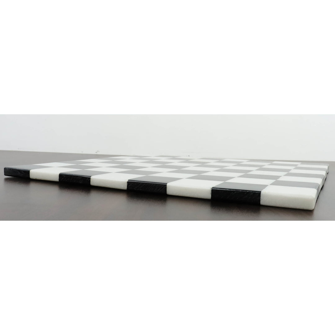 Side profile showing the sleek thickness of a solid black and white marble stone chess board.