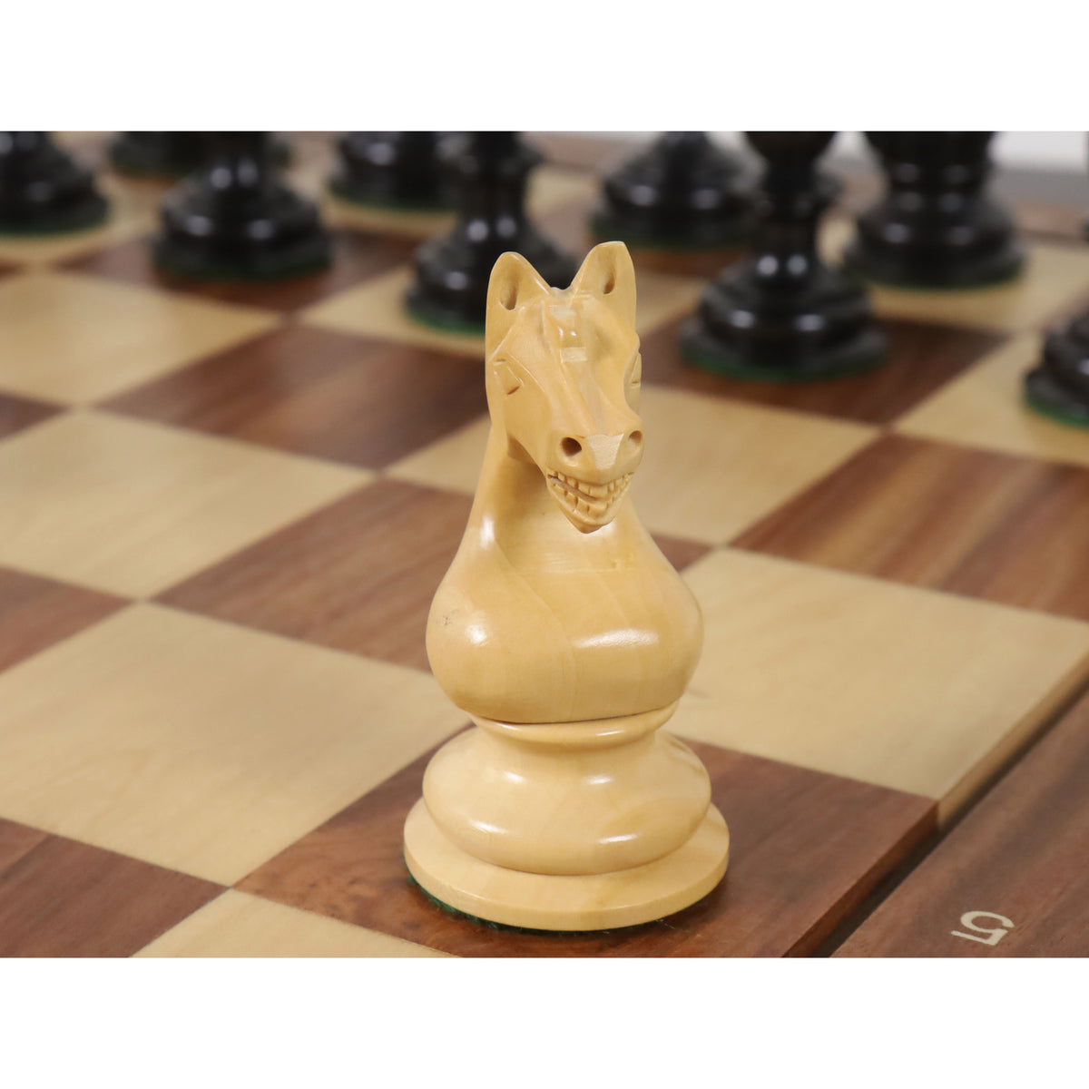 Close-up view of a hand-carved boxwood knight from the Botvinnik Flohr Soviet chess series.